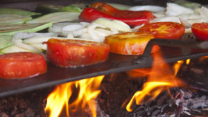 Gemüse auf einer Grillplatte direkt über der Flamme